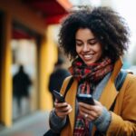 mujer sonriendo mientras usa un móvil en la calle